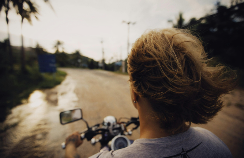 What should you do when overtaking a motorcyclist in strong winds